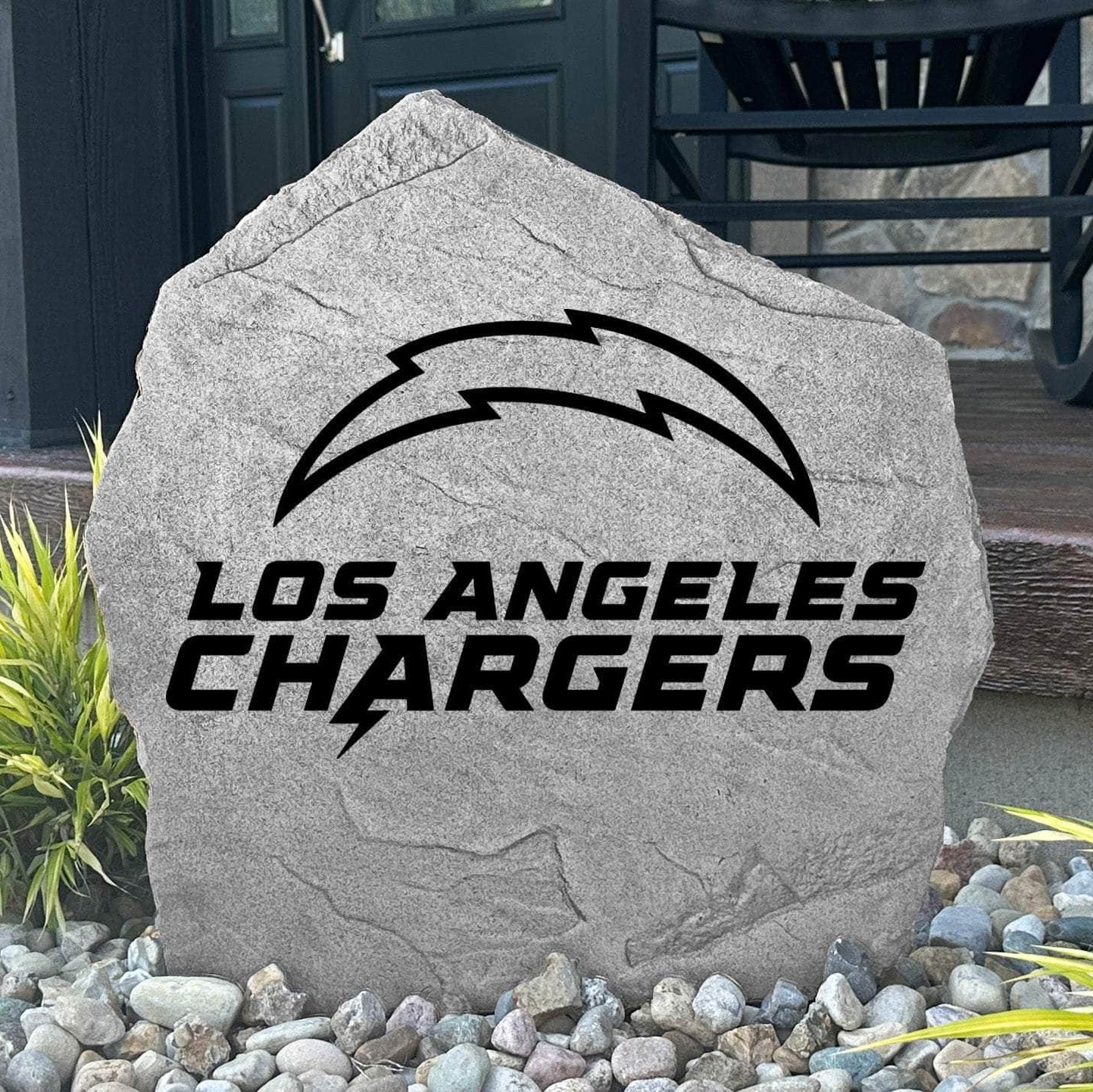 Custom Los Angeles Chargers Logo Stone displayed in a landscaped flower bed, showcasing officially licensed team artwork permanently engraved into the stone. This outdoor accent creates a bold focal point for Chargers fans and outdoor living spaces.