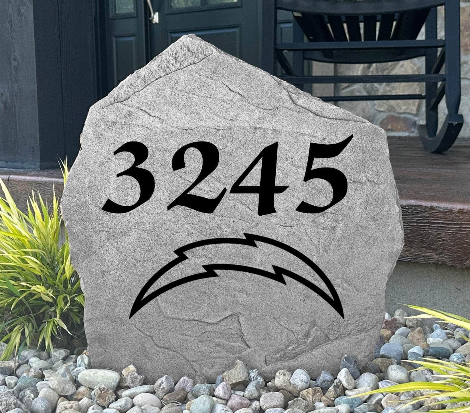 Custom Los Angeles Chargers Address Stone displayed in a landscaped flower bed with personalized house numbers and officially licensed team artwork. This engraved address marker creates a striking focal point for Chargers fans and outdoor living spaces.