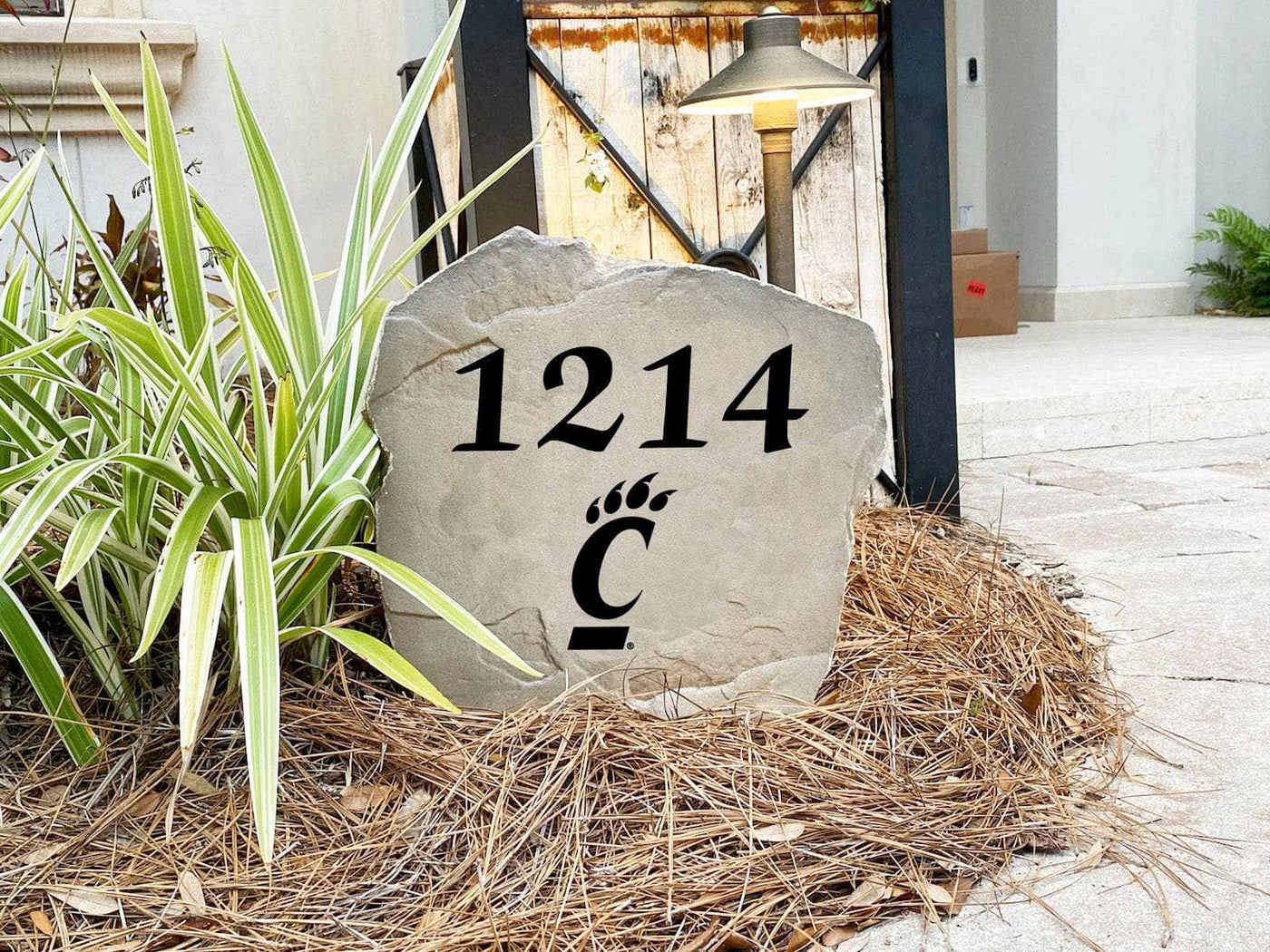 Outdoor address marker stone with University of Cincinnati logo
