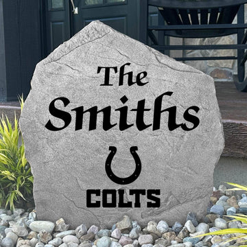 Custom Indianapolis Colts Name Stone displayed in a landscaped flower bed, showcasing personalized family lettering and officially licensed team artwork. This decorative outdoor stone creates a striking focal point for Colts fans and outdoor living spaces.