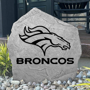 Custom Denver Broncos Logo Stone displayed in a landscaped flower bed, showcasing officially licensed team artwork permanently engraved into the stone. This outdoor accent creates a bold focal point for Broncos fans and outdoor living spaces.