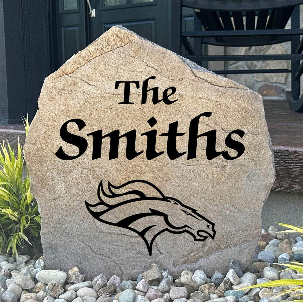 Officially licensed Denver Broncos Name Stone featuring a personalized family name and the iconic Denver Broncos logo engraved directly into the stone surface. This custom garden stone adds NFL team pride and curb appeal to front yards, patios, gardens, and entryways.