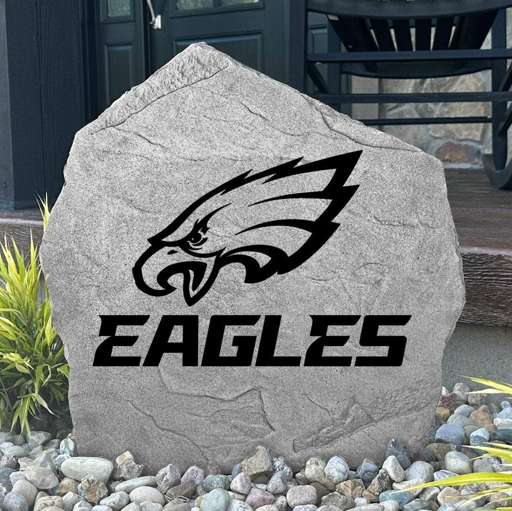 Custom Philadelphia Eagles Logo Stone displayed in a landscaped flower bed, showcasing officially licensed team artwork permanently engraved into the stone. This outdoor accent creates a bold focal point for Eagles fans and outdoor living spaces.