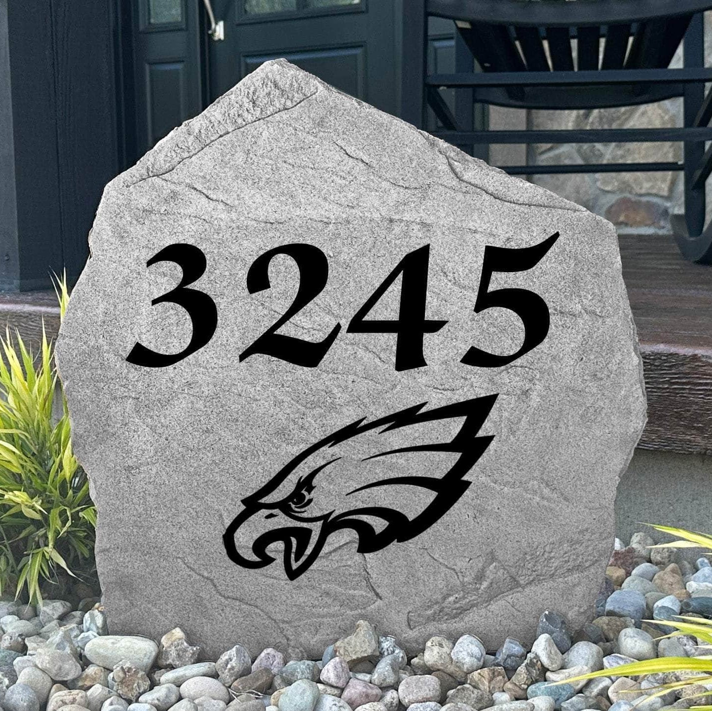 Custom Philadelphia Eagles Address Stone displayed in a landscaped flower bed with personalized house numbers and officially licensed team artwork. This engraved address marker creates a striking focal point for Eagles fans and outdoor living spaces.