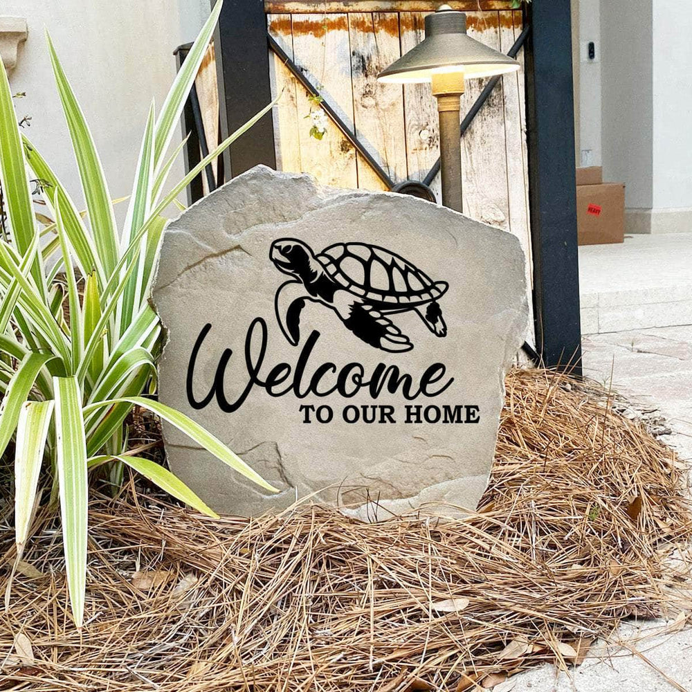 Engraved Welcome Sea Turtle Stone nestled among colorful flowers and natural greenery, bringing beach-inspired beauty and timeless style to gardens, patios, and home entrances.