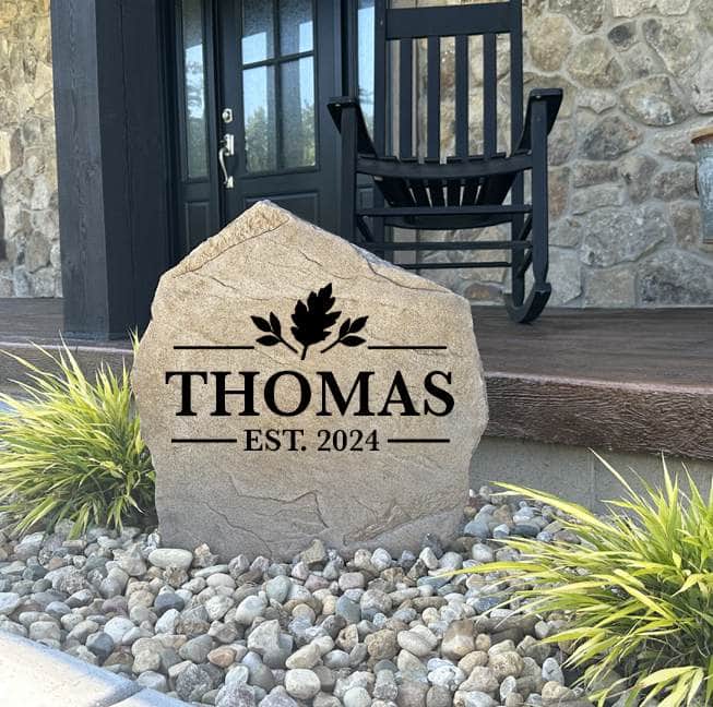 Tan Fall Name Stone engraved THOMAS Est. 2024 in a rock bed at a stone-front porch entryway