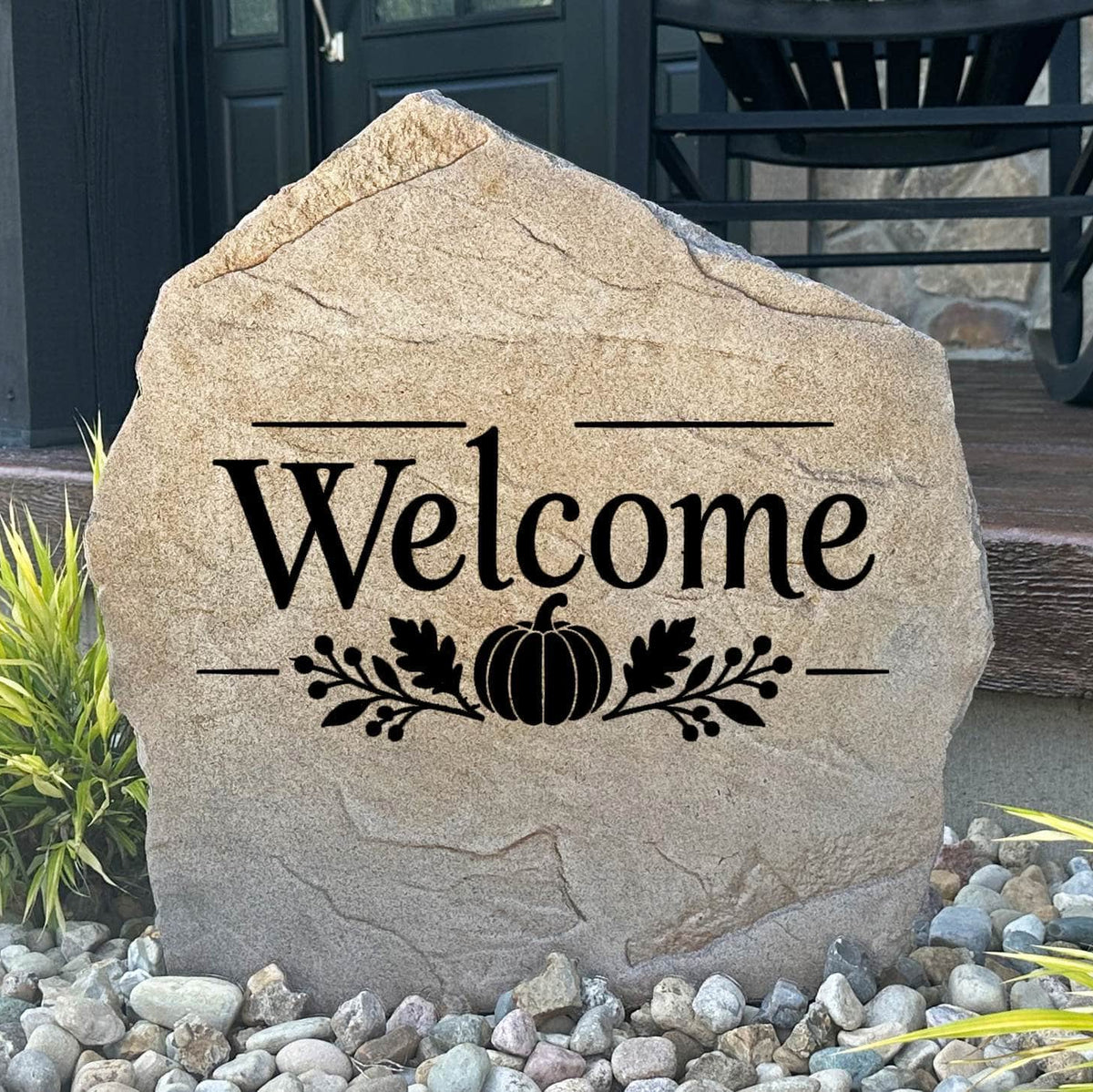 Sandstone Fall Welcome Stone engraved Welcome with a pumpkin and oak leaf design, set in river rock by a front porch