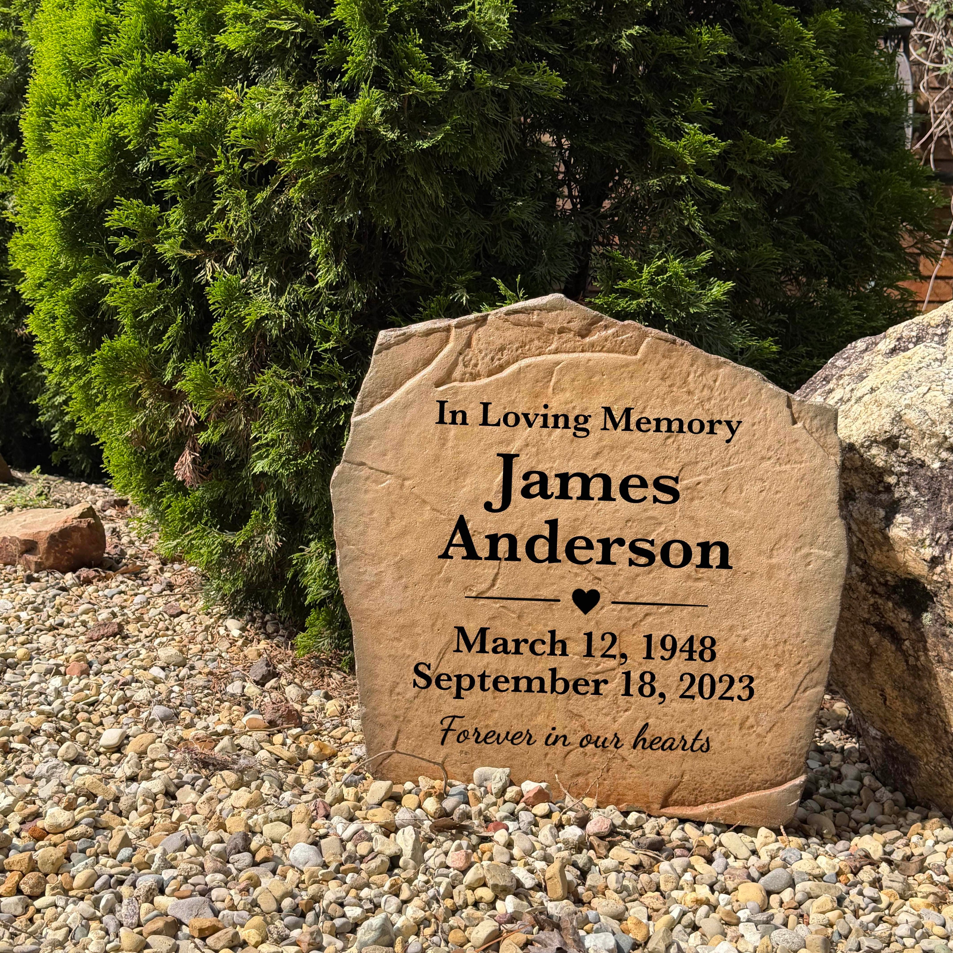Engraved Forever In Our Hearts remembrance stone displayed in a beautiful garden landscape