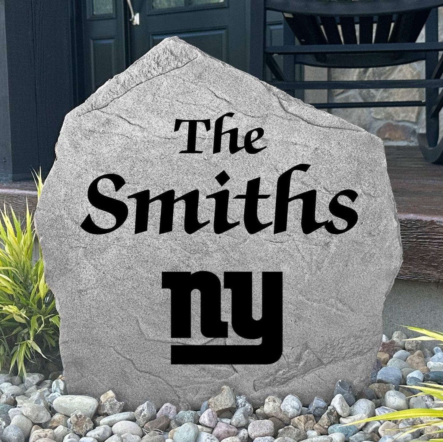 Custom New York Giants Name Stone displayed in a landscaped flower bed, showcasing personalized family lettering and officially licensed team artwork. This decorative outdoor stone creates a striking focal point for Giants fans and outdoor living spaces.