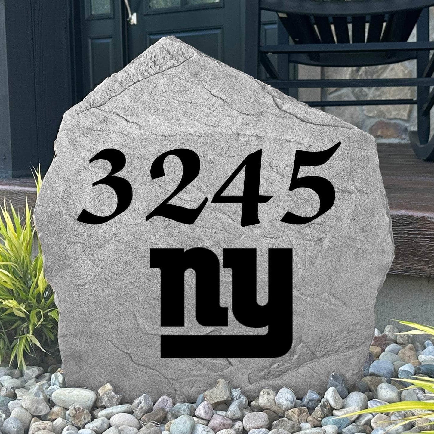 Custom New York Giants Address Stone displayed in a landscaped flower bed with personalized house numbers and officially licensed team artwork. This engraved address marker creates a striking focal point for Giants fans and outdoor living spaces.