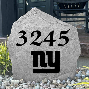 Custom New York Giants Address Stone displayed in a landscaped flower bed with personalized house numbers and officially licensed team artwork. This engraved address marker creates a striking focal point for Giants fans and outdoor living spaces.