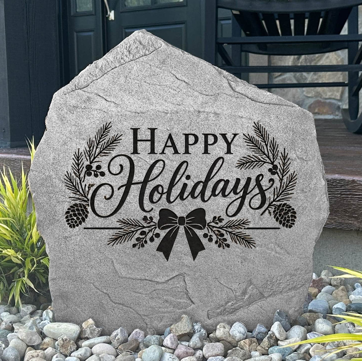 Greystone Happy Holidays Stone with pinecone and ribbon bow engraving beside a black front door