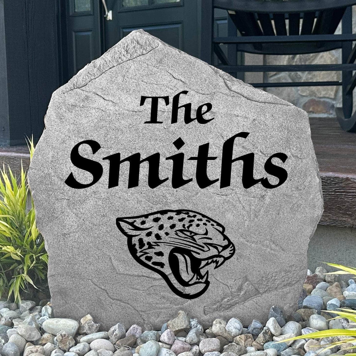 Custom Jacksonville Jaguars Name Stone displayed in a landscaped flower bed, showcasing personalized family lettering and officially licensed team artwork. This decorative outdoor stone creates a striking focal point for Jaguars fans and outdoor living spaces.