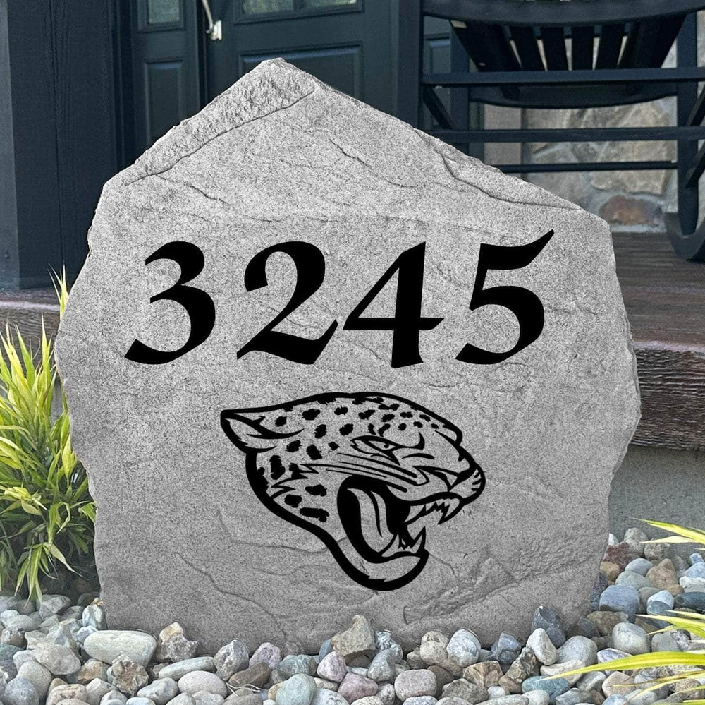 Custom Jacksonville Jaguars Address Stone displayed in a landscaped flower bed with personalized house numbers and officially licensed team artwork. This engraved address marker creates a striking focal point for Jaguars fans and outdoor living spaces.