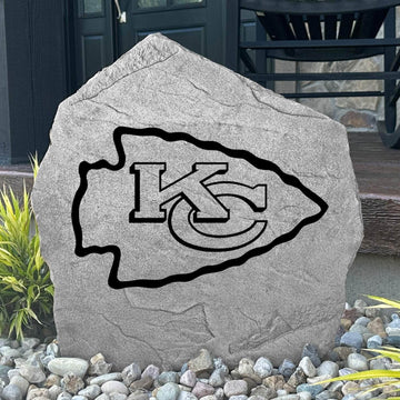 Custom Kansas City Chiefs Logo Stone displayed in a landscaped flower bed, showcasing officially licensed team artwork permanently engraved into the stone. This outdoor accent creates a bold focal point for Chiefs fans and outdoor living spaces.