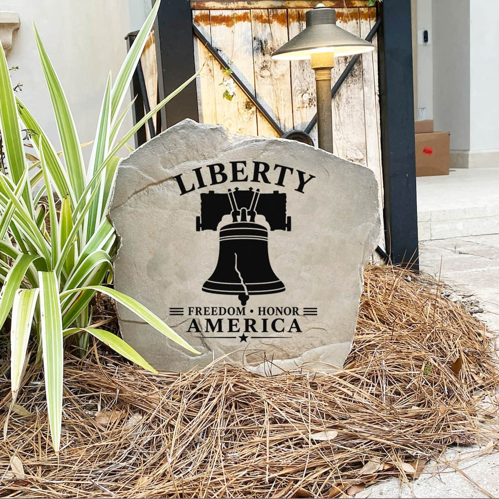 Decorative stone with 'Liberty Freedom Honor America' text and design, placed outdoors.