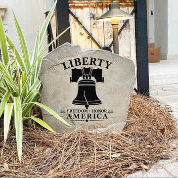 Decorative stone with 'Liberty Freedom Honor America' text and design, placed outdoors.