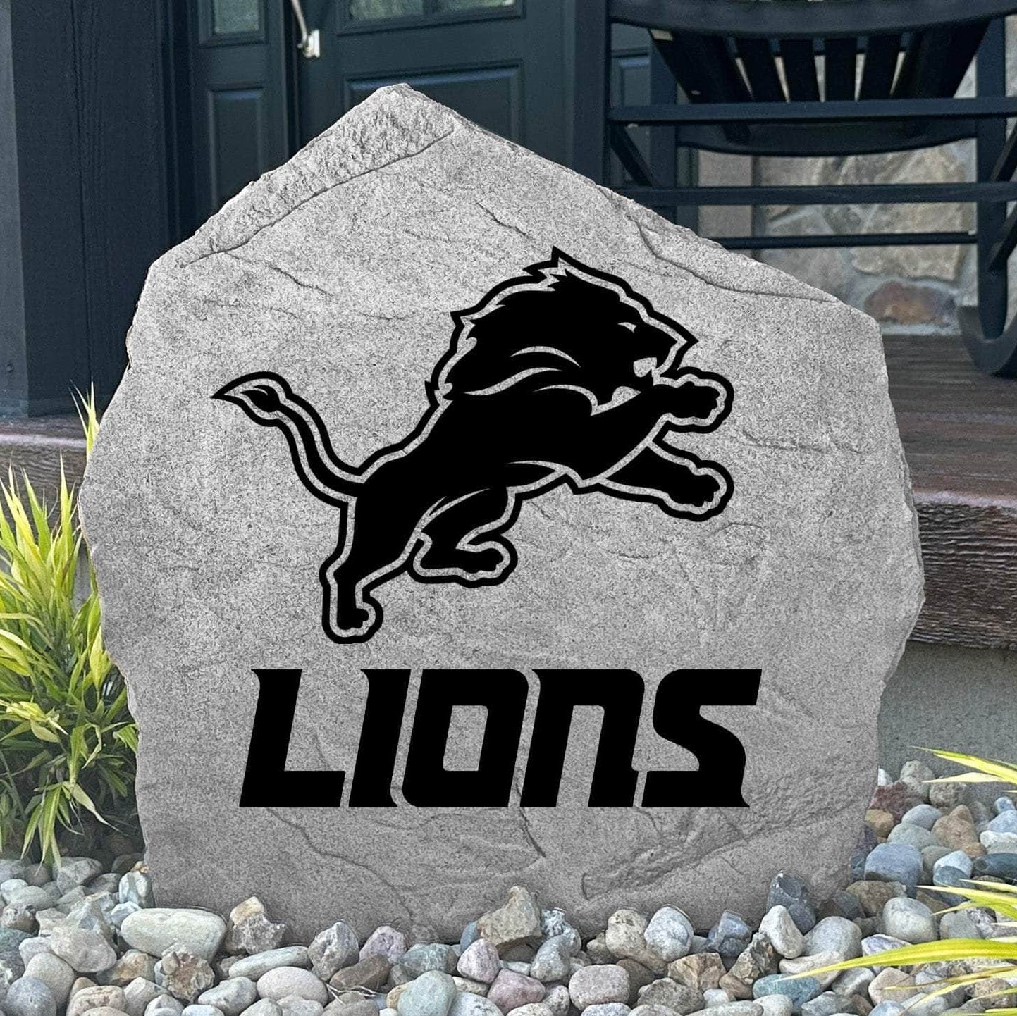 Custom Detroit Lions Logo Stone displayed in a landscaped flower bed, showcasing officially licensed team artwork permanently engraved into the stone. This outdoor accent creates a bold focal point for Lions fans and outdoor living spaces.