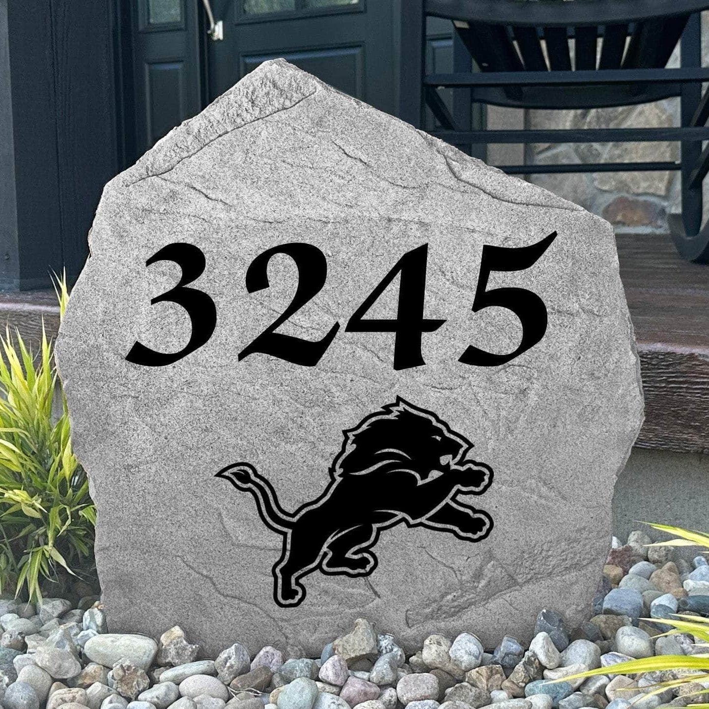 Custom Detroit Lions Address Stone displayed in a landscaped flower bed with personalized house numbers and officially licensed team artwork. This engraved address marker creates a striking focal point for Lions fans and outdoor living spaces.