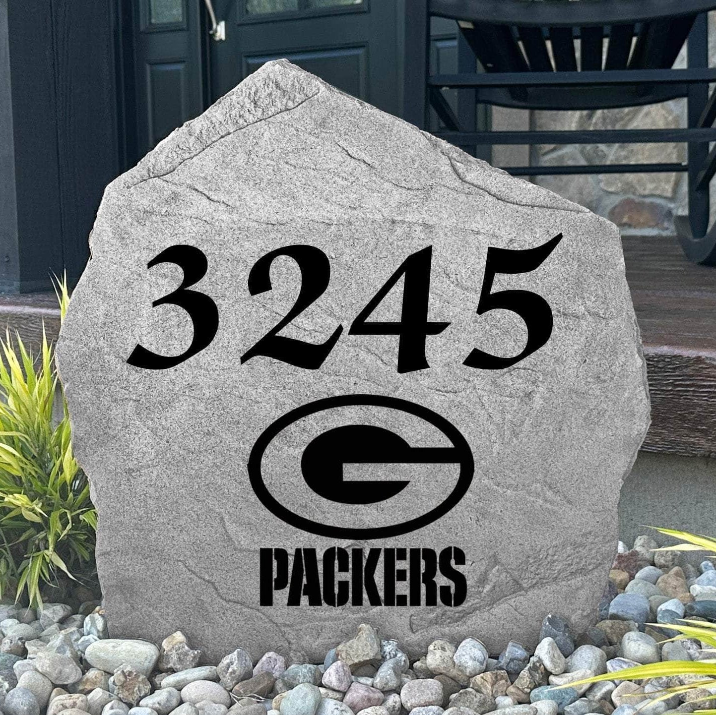 Custom Green Bay Packers Address Stone displayed in a landscaped flower bed with personalized house numbers and officially licensed team artwork. This engraved address marker creates a striking focal point for Packers fans and outdoor living spaces.