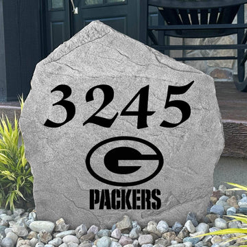 Custom Green Bay Packers Address Stone displayed in a landscaped flower bed with personalized house numbers and officially licensed team artwork. This engraved address marker creates a striking focal point for Packers fans and outdoor living spaces.