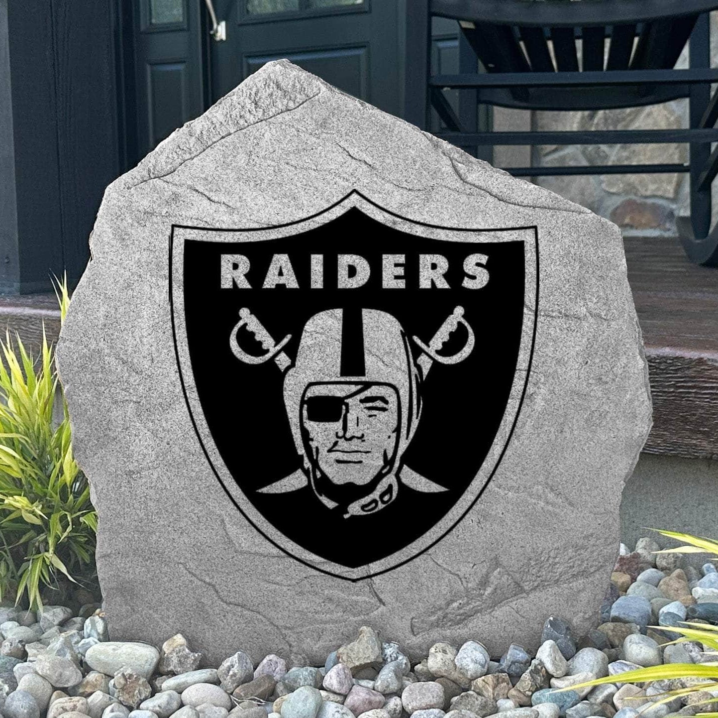 Custom Las Vegas Raiders Logo Stone displayed in a landscaped flower bed, showcasing officially licensed team artwork permanently engraved into the stone. This outdoor accent creates a bold focal point for Raiders fans and outdoor living spaces.