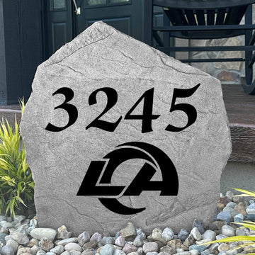 Custom Los Angeles Rams Address Stone displayed in a landscaped flower bed with personalized house numbers and officially licensed team artwork. This engraved address marker creates a striking focal point for Rams fans and outdoor living spaces.