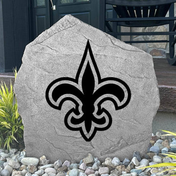 Custom New Orleans Saints Logo Stone displayed in a landscaped flower bed, showcasing officially licensed team artwork permanently engraved into the stone. This outdoor accent creates a bold focal point for Saints fans and outdoor living spaces.