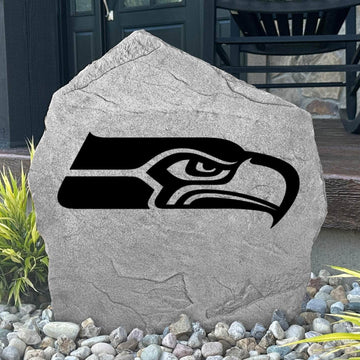 Custom Seattle Seahawks Logo Stone displayed in a landscaped flower bed, showcasing officially licensed team artwork permanently engraved into the stone. This outdoor accent creates a bold focal point for Seahawks fans and outdoor living spaces.