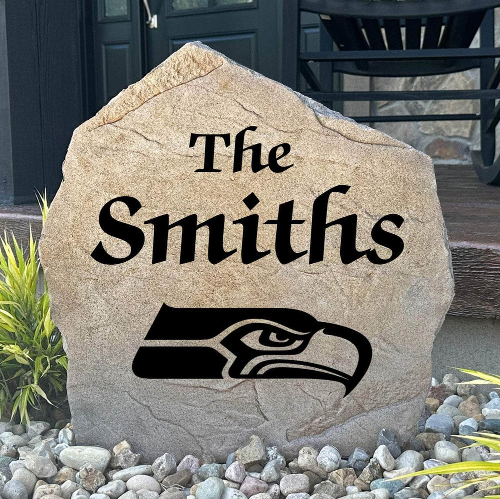 Officially licensed Seattle Seahawks Name Stone featuring a personalized family name and the iconic Seattle Seahawks logo engraved directly into the stone surface. This custom garden stone adds NFL team pride and curb appeal to front yards, patios, gardens, and entryways.