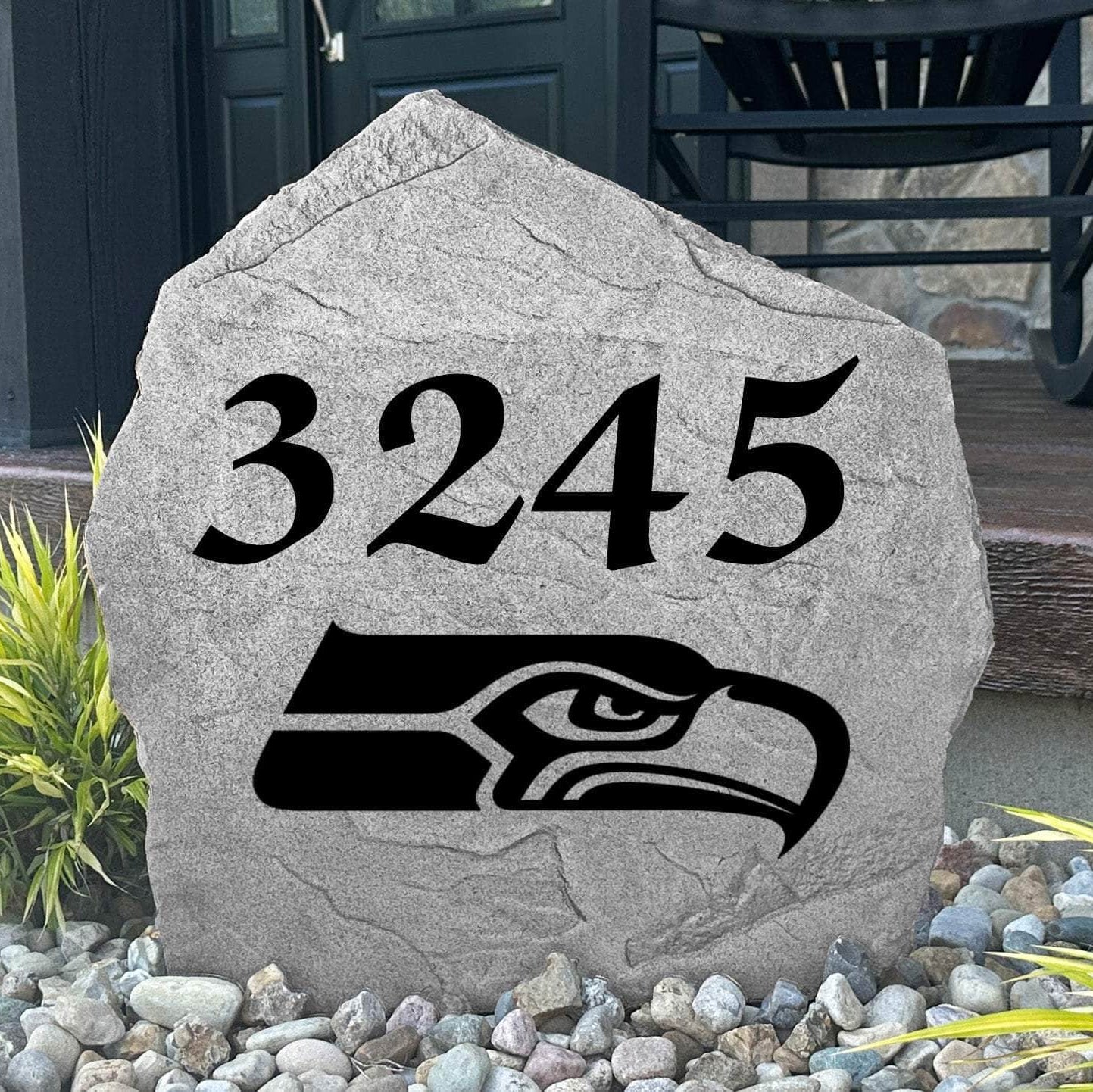Custom Seattle Seahawks Address Stone displayed in a landscaped flower bed with personalized house numbers and officially licensed team artwork. This engraved address marker creates a striking focal point for Seahawks fans and outdoor living spaces.