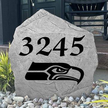 Custom Seattle Seahawks Address Stone displayed in a landscaped flower bed with personalized house numbers and officially licensed team artwork. This engraved address marker creates a striking focal point for Seahawks fans and outdoor living spaces.