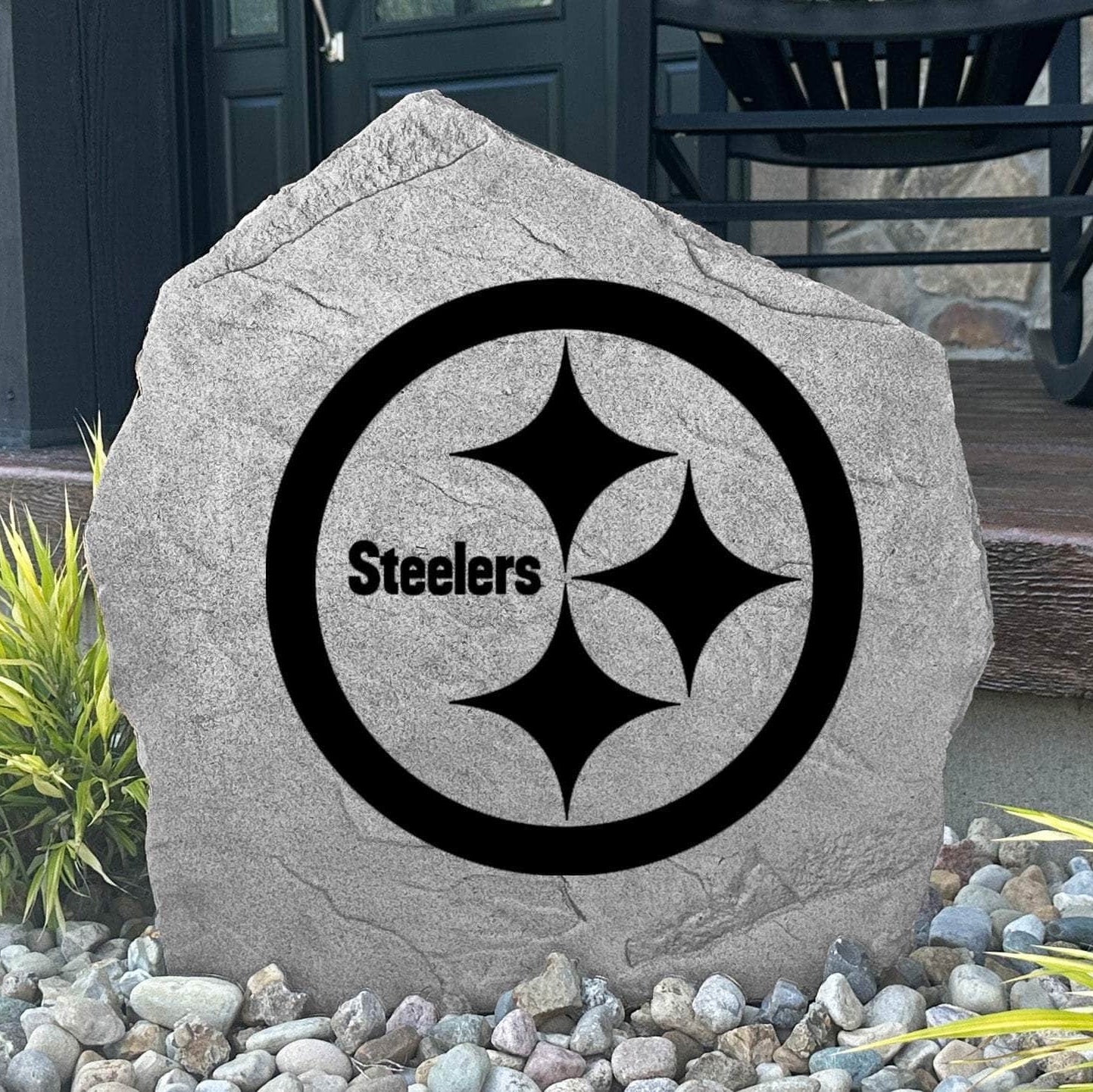 Custom Pittsburgh Steelers Logo Stone displayed in a landscaped flower bed, showcasing officially licensed team artwork permanently engraved into the stone. This outdoor accent creates a bold focal point for Steelers fans and outdoor living spaces.