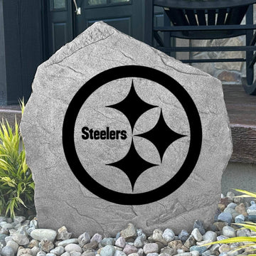 Custom Pittsburgh Steelers Logo Stone displayed in a landscaped flower bed, showcasing officially licensed team artwork permanently engraved into the stone. This outdoor accent creates a bold focal point for Steelers fans and outdoor living spaces.