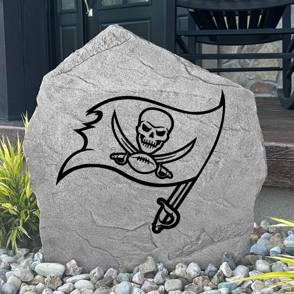 Custom Tampa Bay Buccaneers Logo Stone displayed in a landscaped flower bed, showcasing officially licensed team artwork permanently engraved into the stone. This outdoor accent creates a bold focal point for Buccaneers fans and outdoor living spaces.