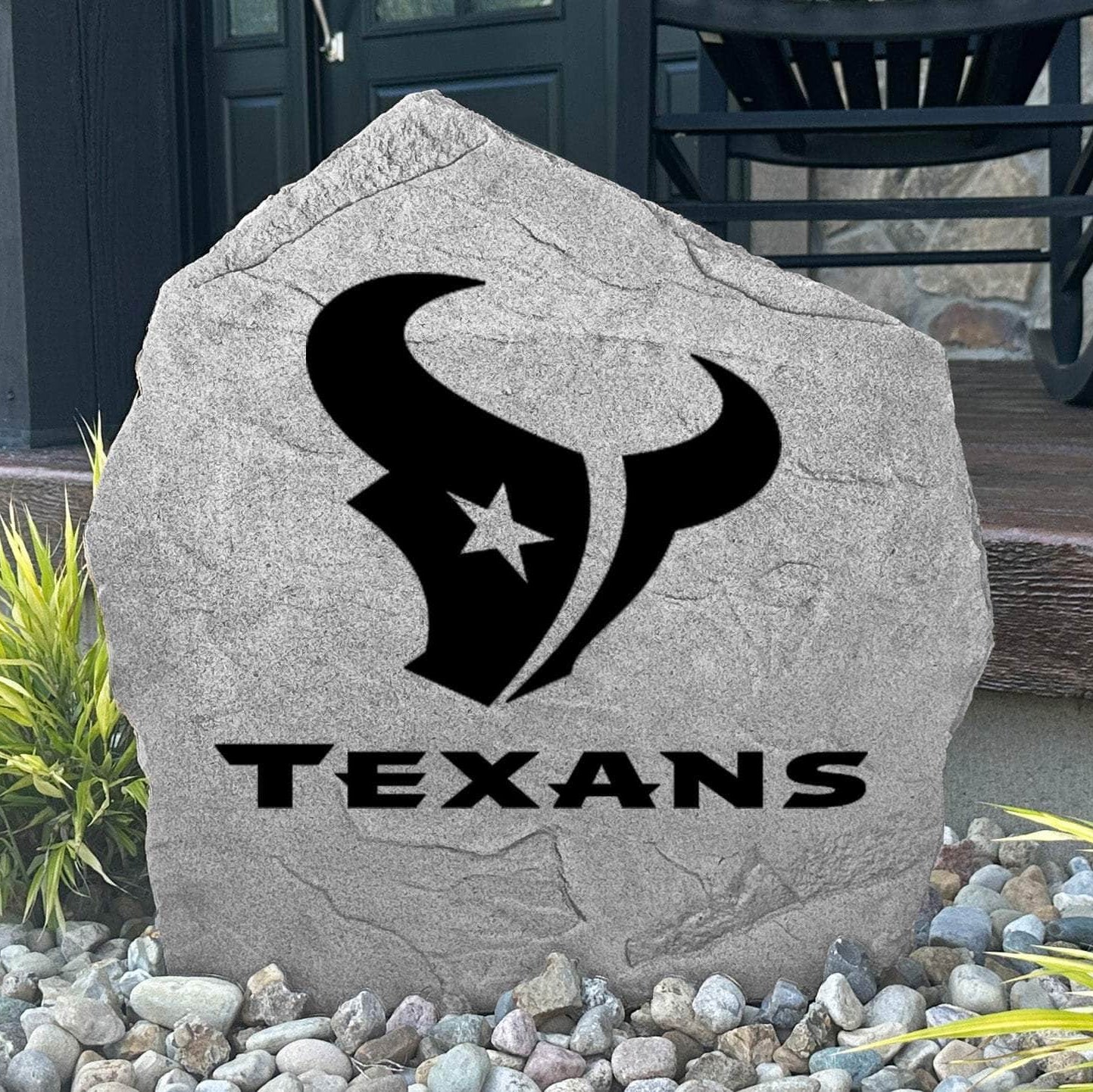 Custom Houston Texans Logo Stone displayed in a landscaped flower bed, showcasing officially licensed team artwork permanently engraved into the stone. This outdoor accent creates a bold focal point for Texans fans and outdoor living spaces.