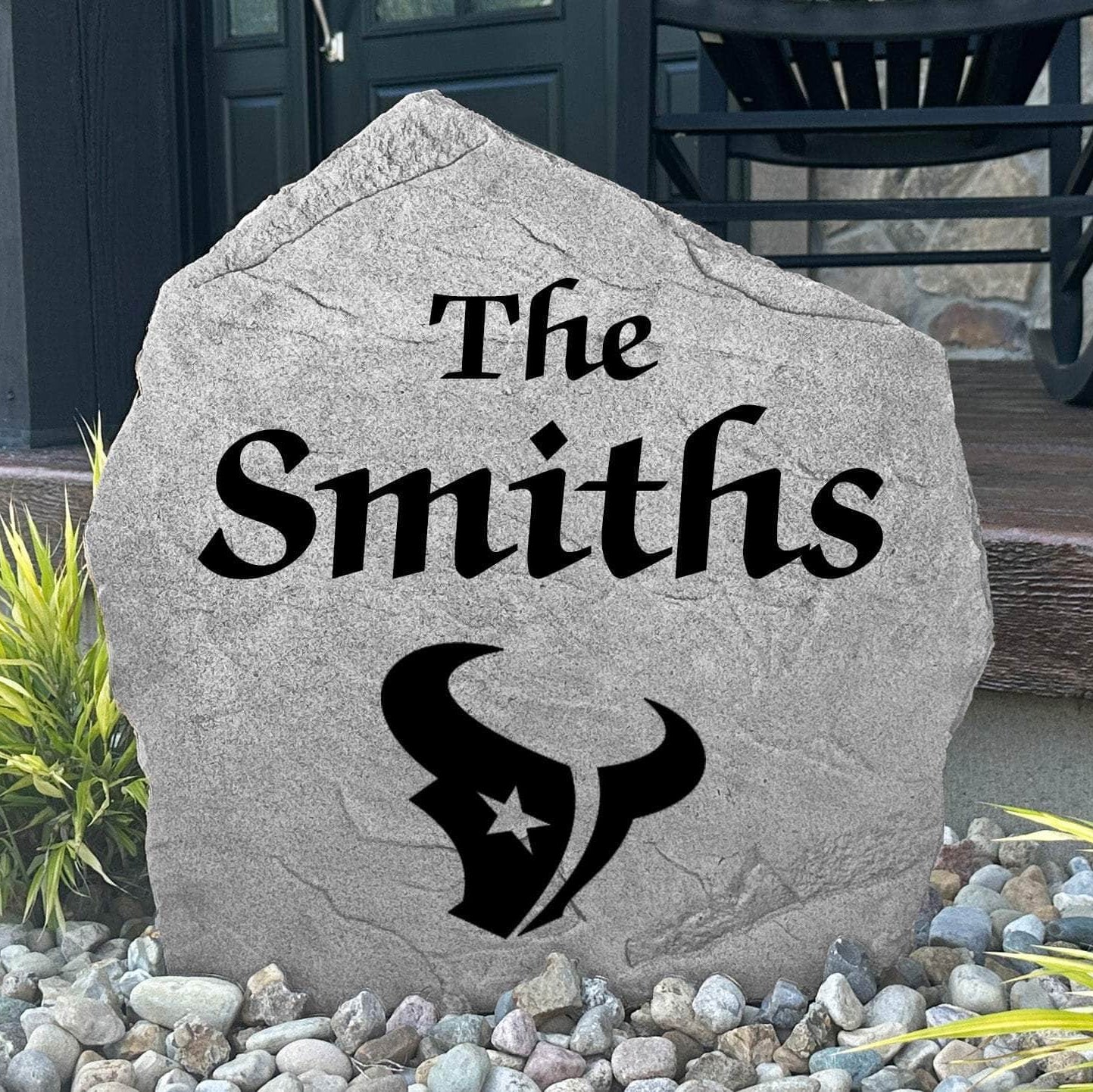 Custom Houston Texans Name Stone displayed in a landscaped flower bed, showcasing personalized family lettering and officially licensed team artwork. This decorative outdoor stone creates a striking focal point for Texans fans and outdoor living spaces.