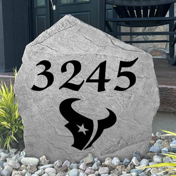 Custom Houston Texans Address Stone displayed in a landscaped flower bed with personalized house numbers and officially licensed team artwork. This engraved address marker creates a striking focal point for Texans fans and outdoor living spaces.