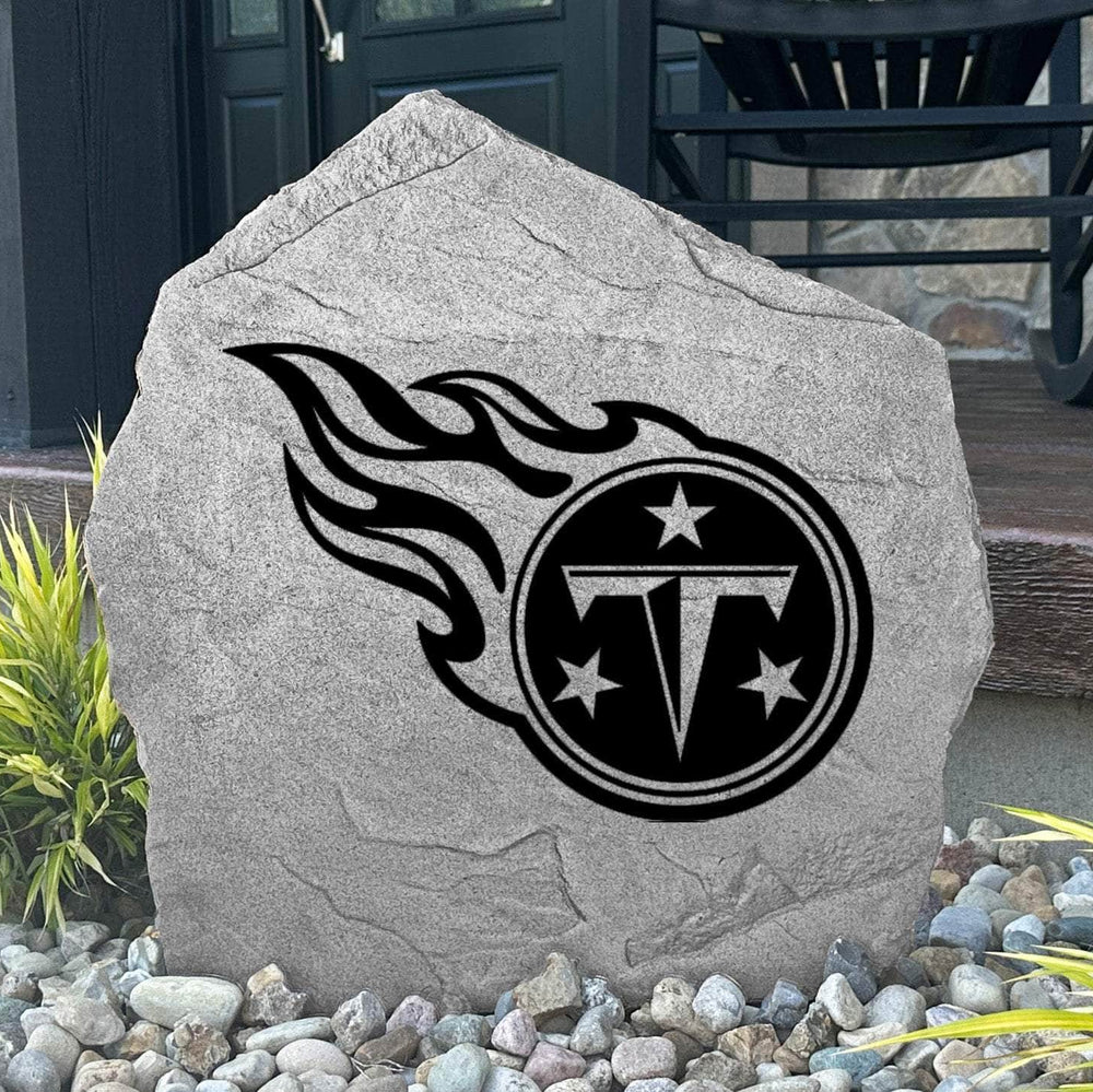Custom Tennessee Titans Logo Stone displayed in a landscaped flower bed, showcasing officially licensed team artwork permanently engraved into the stone. This outdoor accent creates a bold focal point for Titans fans and outdoor living spaces.