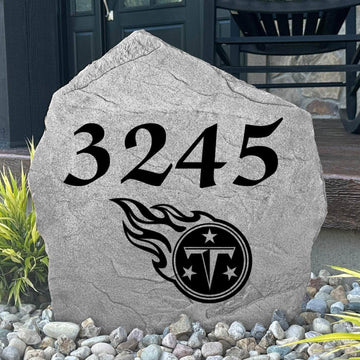 Custom Tennessee Titans Address Stone displayed in a landscaped flower bed with personalized house numbers and officially licensed team artwork. This engraved address marker creates a striking focal point for Titans fans and outdoor living spaces.