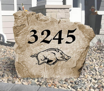 University of Arkansas Razorbacks address stone displayed in landscaped yard.
