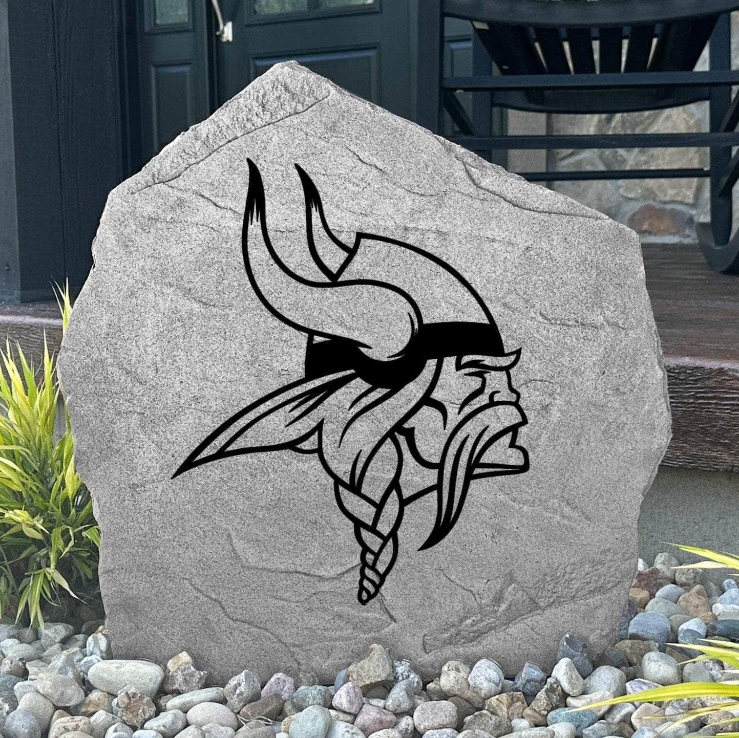 Custom Minnesota Vikings Logo Stone displayed in a landscaped flower bed, showcasing officially licensed team artwork permanently engraved into the stone. This outdoor accent creates a bold focal point for Vikings fans and outdoor living spaces.