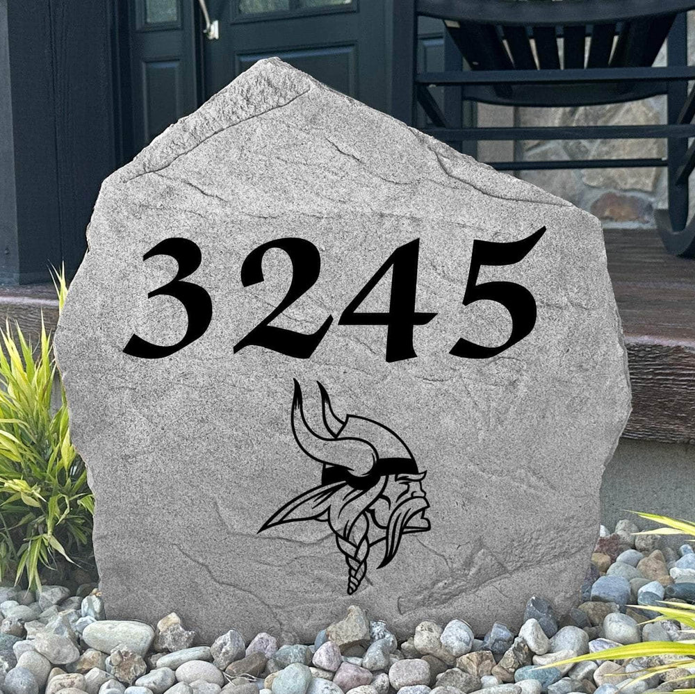 Custom Minnesota Vikings Address Stone displayed in a landscaped flower bed with personalized house numbers and officially licensed team artwork. This engraved address marker creates a striking focal point for Vikings fans and outdoor living spaces.
