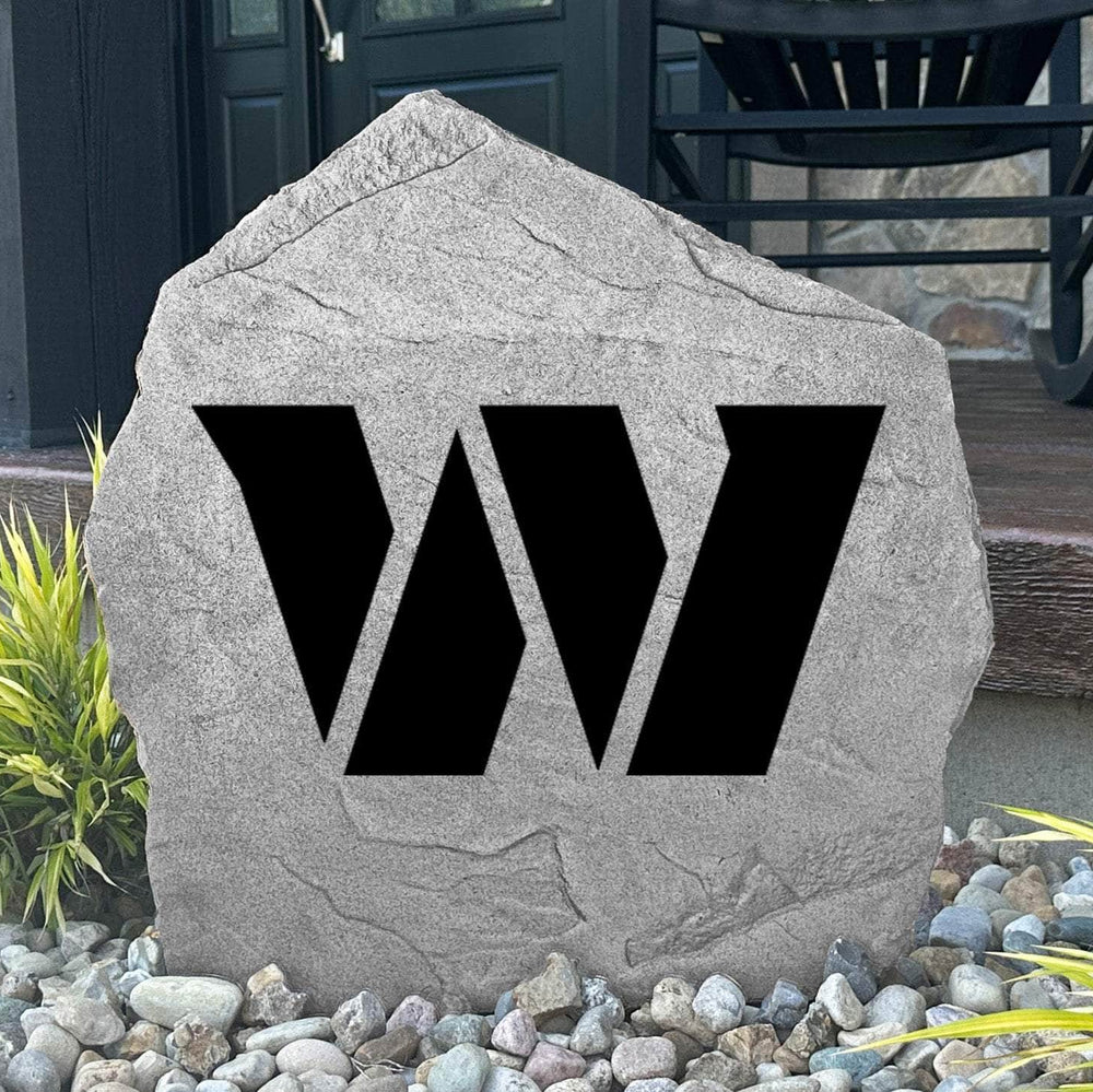 Custom Washington Commanders Logo Stone displayed in a landscaped flower bed, showcasing officially licensed team artwork permanently engraved into the stone. This outdoor accent creates a bold focal point for football fans and outdoor living spaces.