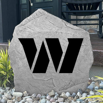 Custom Washington Commanders Logo Stone displayed in a landscaped flower bed, showcasing officially licensed team artwork permanently engraved into the stone. This outdoor accent creates a bold focal point for football fans and outdoor living spaces.