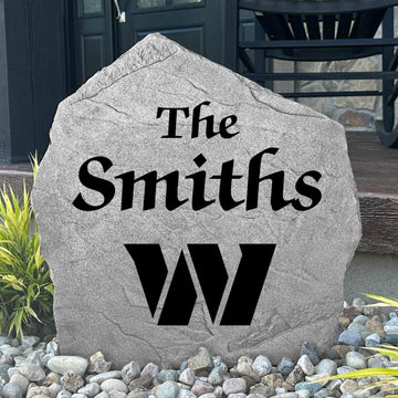 Custom Washington Commanders Name Stone displayed in a landscaped flower bed, showcasing personalized family lettering and officially licensed team artwork. This decorative outdoor stone creates a striking focal point for football fans and outdoor living spaces.