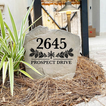 Winter Address Stone engraved 2645 Prospect Drive on pine straw next to a rustic gate and landscape light