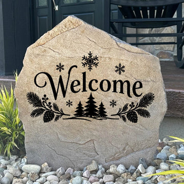 Sandstone Winter Welcome Stone engraved Welcome with pine trees and snowflakes, set in river rock by a porch