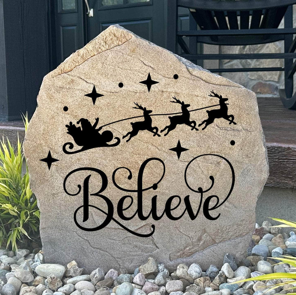 Engraved Believe Holiday Stone featuring a festive seasonal message carved directly into the stone surface. This decorative Christmas garden stone adds warmth and holiday charm to front porches, entryways, patios, and winter landscapes.