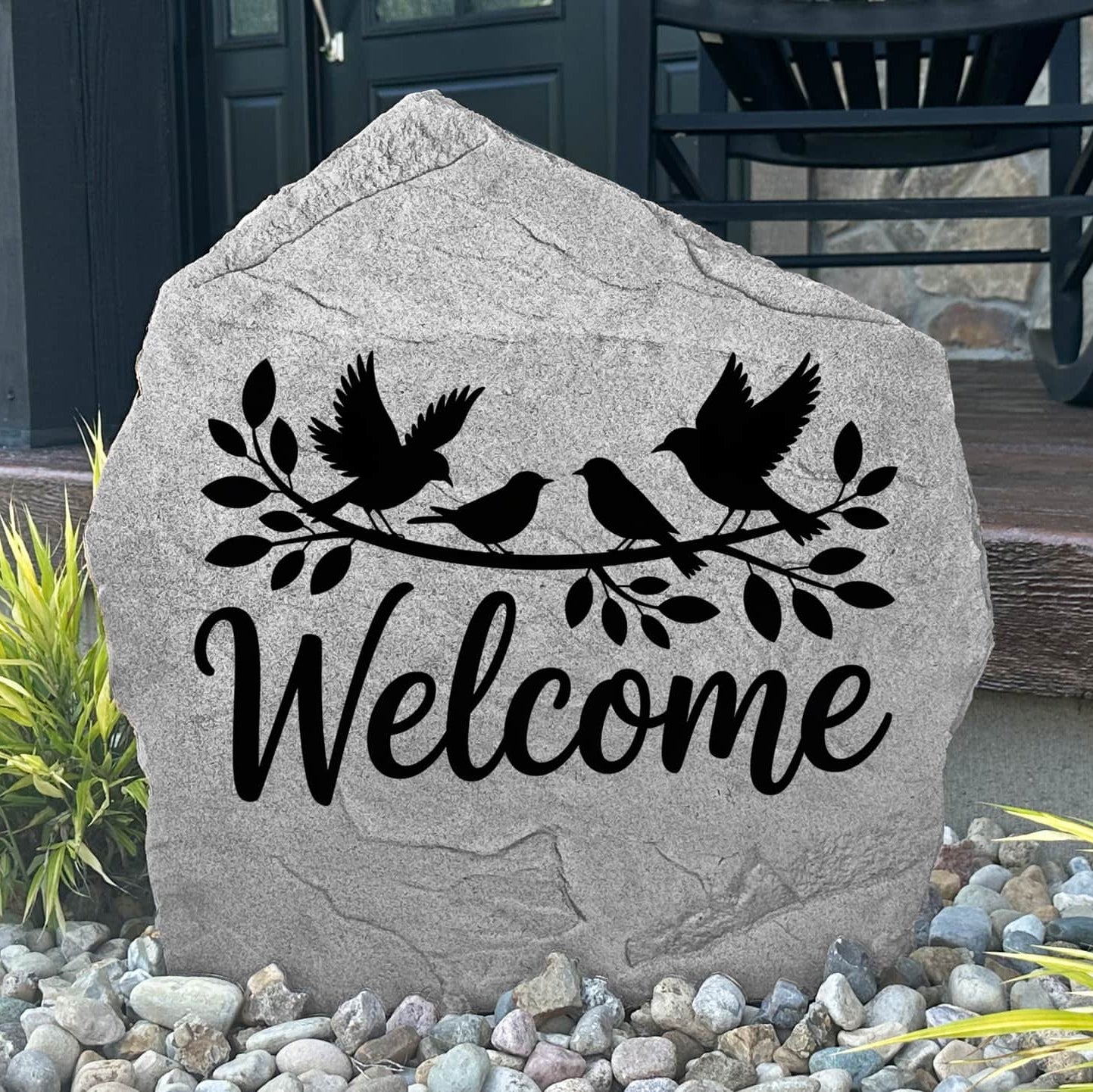 Engraved Welcome Bird Stone displayed in a landscaped garden, showcasing detailed bird artwork and a warm welcome message. This outdoor accent creates a beautiful focal point for walkways, porches, and flower beds.